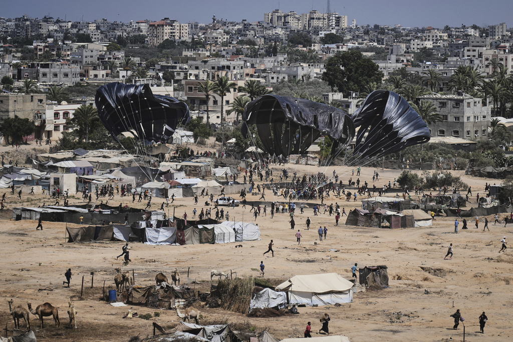 FILE - Palestinians rush to collect humanitarian aid airdropped into Zawaida in central Gaza Strip, July 31, 2025. (AP Photo/Abdel Kareem Hana, File)