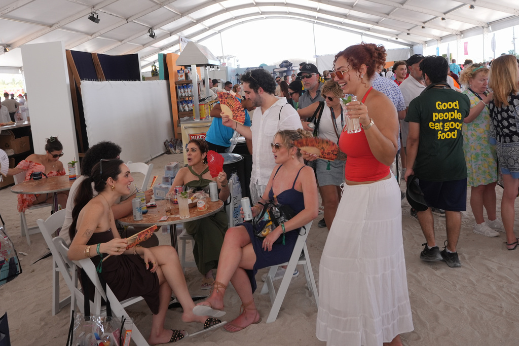 Friends take a break during the South Beach Wine and Food Festival Saturday, Feb. 21, 2026, in Miami Beach, Fla. (AP Photo/Marta Lavandier)