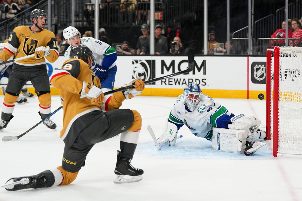 Vegas Golden Knights right wing Reilly Smith (19) scores against Vancouver Canucks goaltender Kevin Lankinen, right, during the second period of an NHL hockey game Monday, March 30, 2026, in Las Vegas. (AP Photo/Candice Ward)