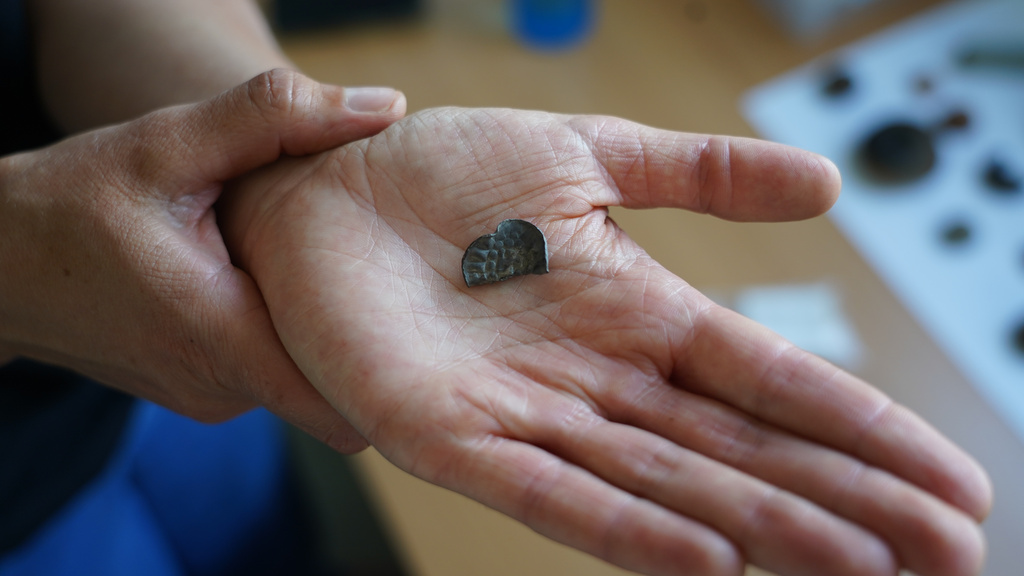 Moesgaard Museum archaeologist Liv Stidsing Reher-Langberg holds a Viking Age silver coin unearthed in Aarhus, Denmark, Monday, June 22, 2026. (AP Photo/James Brooks)