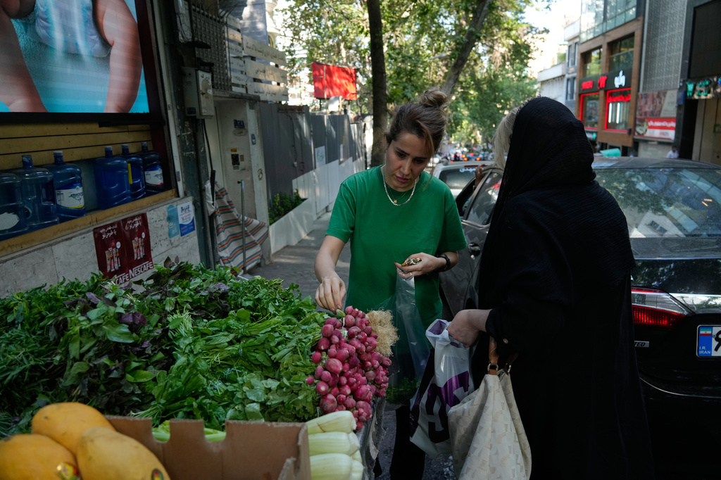 Women buy vegetables in northern Tehran, Iran, Wednesday, June 10, 2026. (AP Photo/Vahid Salemi)
