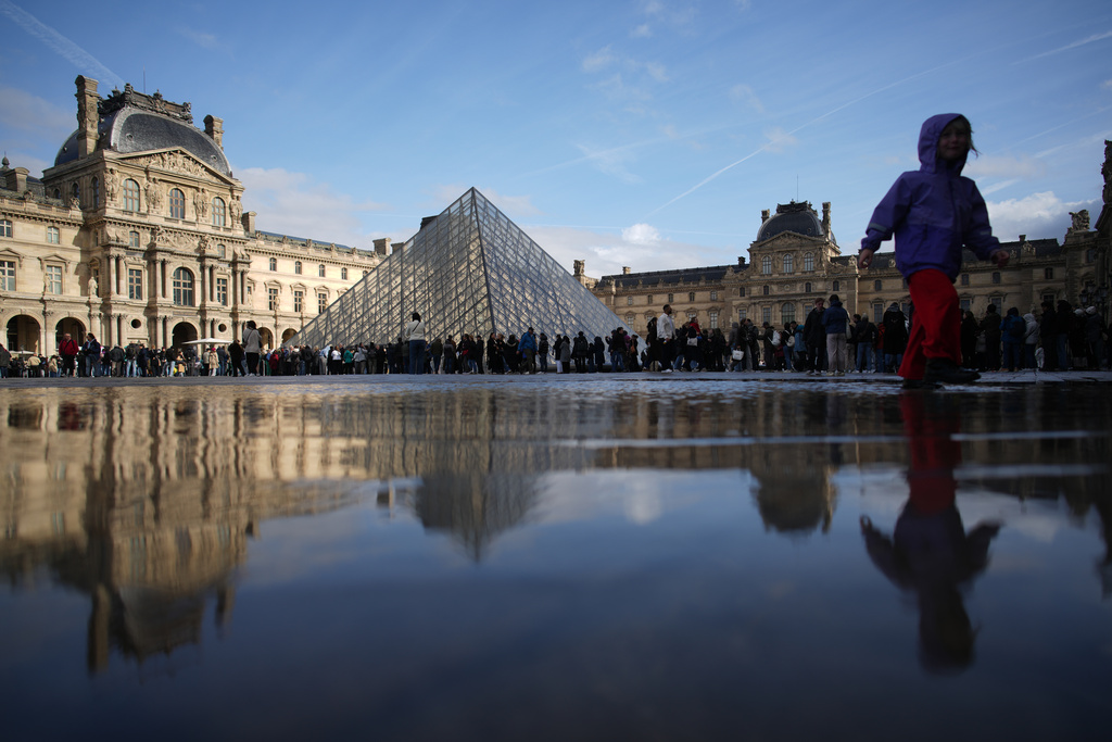 People queue to enter Le Louvre museum Monday, Oct. 27, 2025 in Paris. (AP Photo/Christophe Ena)