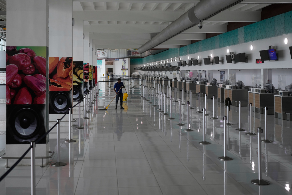 A janitor mops the floor at Norman Manley International Airport, closed ahead of the forecast arrival of Hurricane Melissa, in Kingston, Jamaica, Sunday, Oct. 26, 2025. (AP Photo/Matias Delacroix)