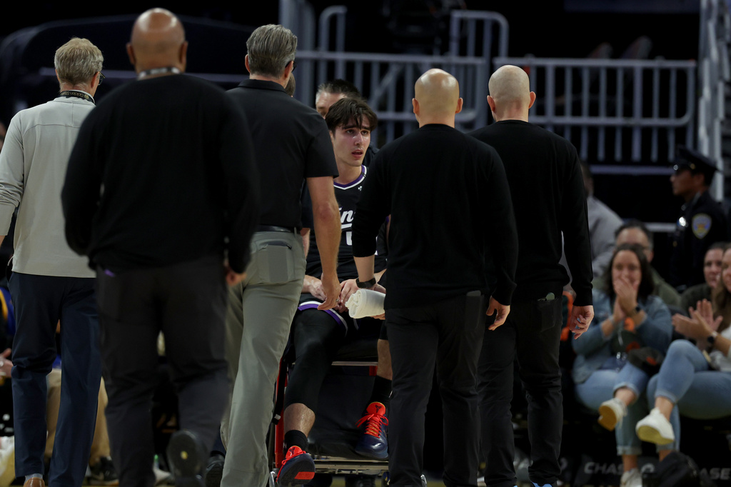 Sacramento Kings center Maxime Raynaud , center, leaves with an injury during the first half of a preseason NBA basketball game against the Golden State Warriors in San Francisco, Saturday, Oct. 10, 2026. (AP Photo/Jed Jacobsohn)