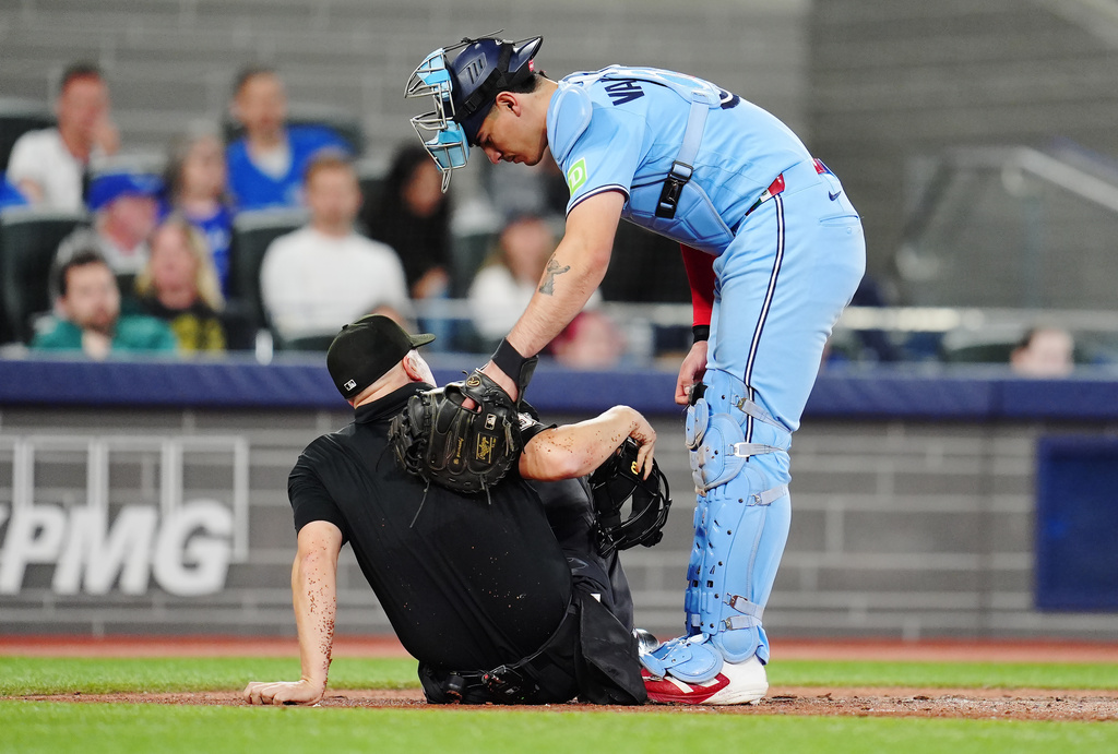 Toronto Blue Jays catcher Brandon Valenzuela (right) checks on umpire Chris Segal after he was hit by a pitch during sixth inning MLB baseball action against the Tampa Bay Rays in Toronto on Tuesday, May 12, 2026. (Frank Gunn/The Canadian Press via AP)