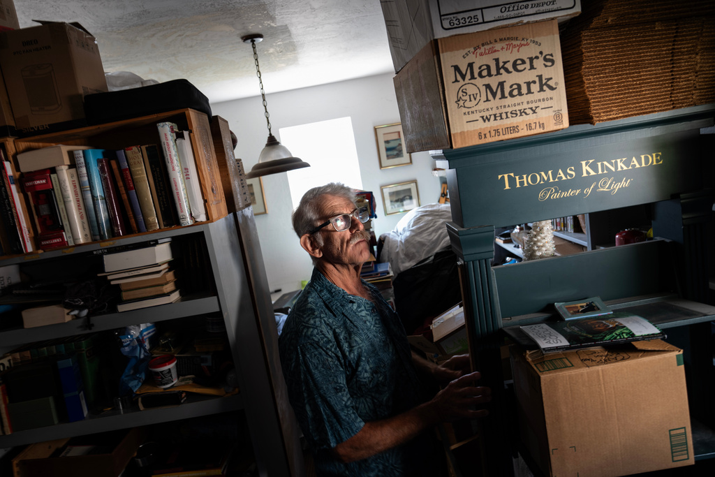 Christy Morrill, who lost decades of memories to autoimmune encephalitis, walks through his garage where he stores his book collection, Wednesday, Aug. 20, 2025, in San Carlos, Calif. (AP Photo/David Goldman)