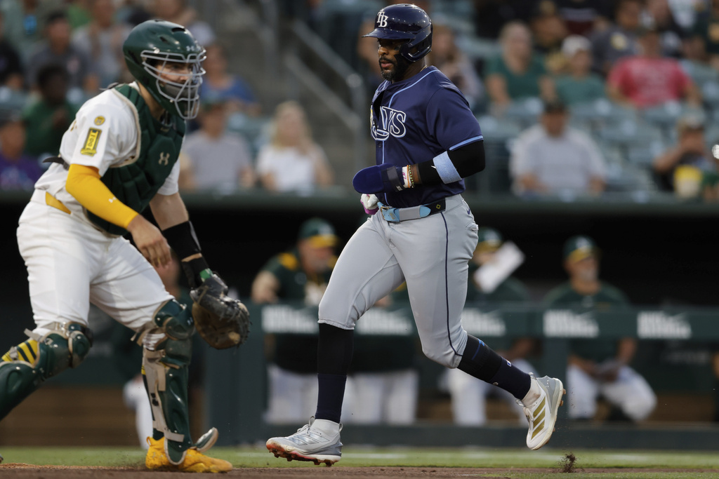 Tampa Bay Rays' Brandon Lowe, right, scores during the third inning of a baseball game against the Athletics, Monday, Aug. 11, 2025, in West Sacramento, Calif. (AP Photo/Sergio Estrada)