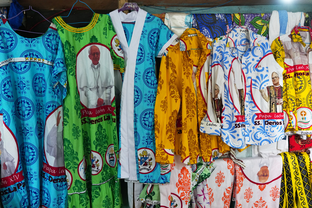 Garments featuring printed images of Pope Leo XIV are on display in a tailor's shop ahead of the Pope's visit in Malabo, Equatorial Guinea, Saturday, April 18, 2026. (AP Photo/Misper Apawu)
