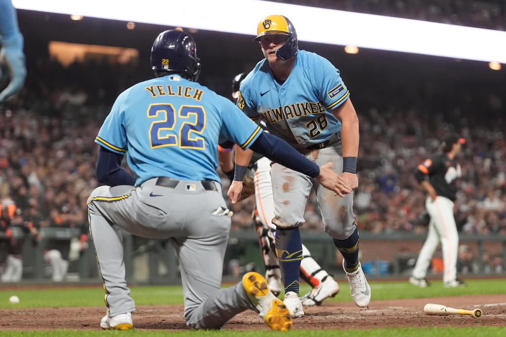 Milwaukee Brewers' Christian Yelich (22) celebrates with Andrew Vaughn (28) after both scored on a two-run triple hit by Luis Lara during the seventh inning of a baseball game against the San Francisco Giants, Tuesday, July 28, 2026, in San Francisco. (AP Photo/Jeff Chiu)
