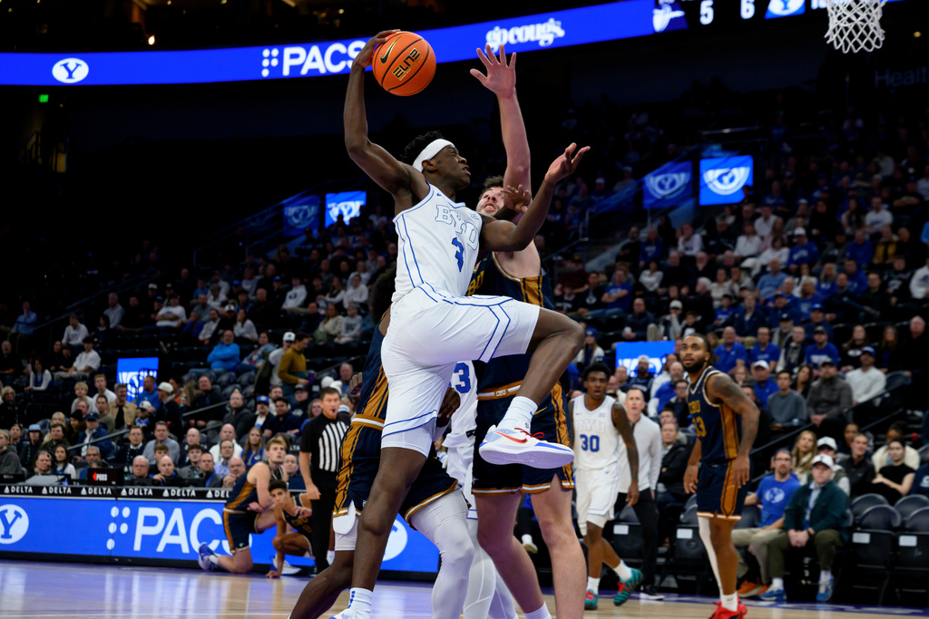 Brigham Young forward AJ Dybantsa, front, drives to the basket guarded by California Baptist center Nate Garcia, rear, during the first half of an NCAA college basketball game, Wednesday, Dec. 3, 2025, in Salt Lake City. (AP Photo/Tyler Tate)