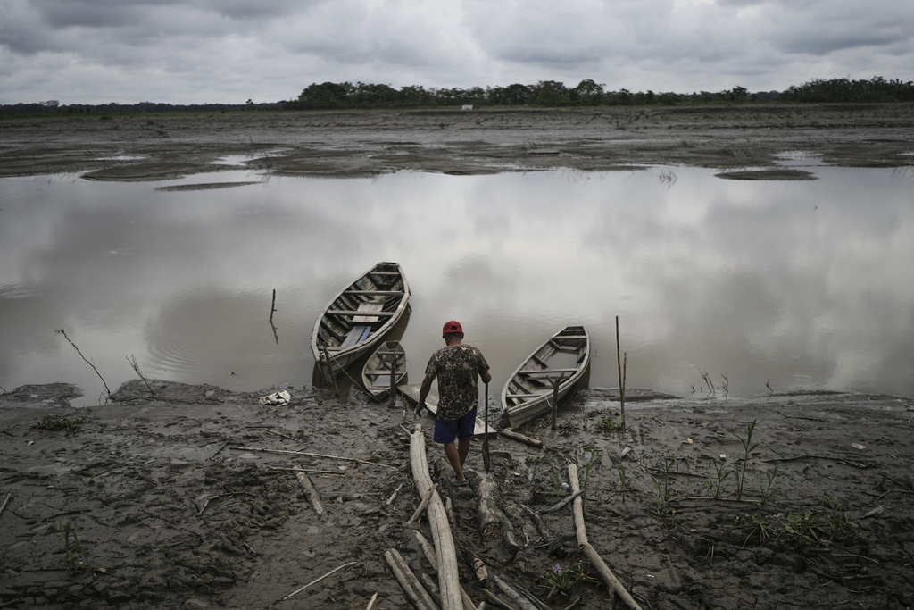 A fisherman walks to his boat in Santa Rosa, Peru, an island on the Amazon River at the center of a territorial dispute with Colombia, Sunday, Aug. 17, 2025. (AP Photo/Ivan Valencia)