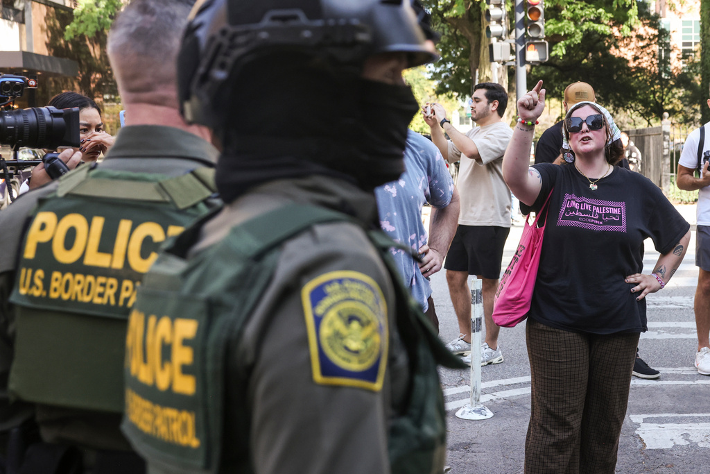 Pedestrians yell at federal agents from U.S. Immigration and Customs Enforcement and U.S. Customs and Border Protection as they stand on North Clark Street at West Oak Street in River North, Sunday, Sept. 28, 2025, in Chicago. (Ashlee Rezin/Chicago Sun-Times via AP)