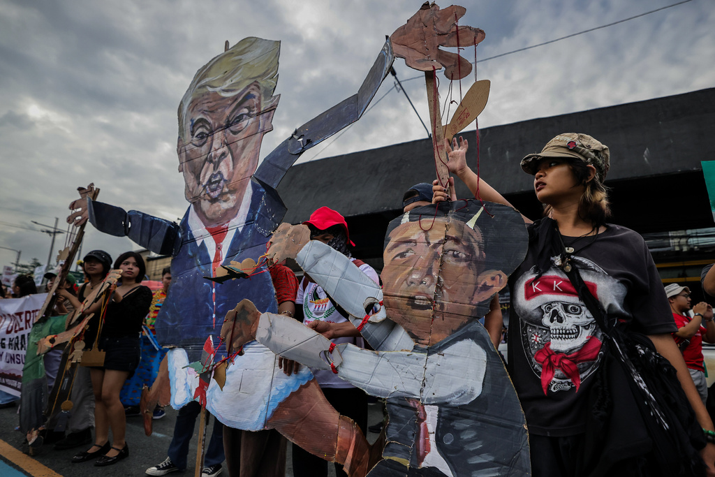 Protesters carry an effigy of U.S. President Donald Trump and Philippine President Ferdinand Marcos Jr. during a protest march in Quezon City, Philippines Monday, July 27, 2026, ahead of the State of the Nation Address by President Marcos Jr. (AP Photo/Gerard Carreon)