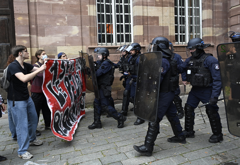 Protesters of the "Block Everything" movement face French police as they hold a banner that reads, "one hero, the people, blocking everything" in Strasbourg, eastern France, Wednesday, Sept. 10, 2025. (AP Photo/Pascal Bastien)