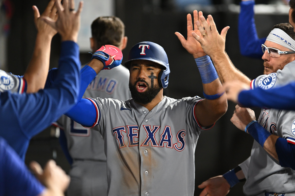 Texas Rangers' Ezequiel Duran, center, celebrates with teammates in the dugout after scoring on a wild pitch during the eighth inning of a baseball game against the Chicago White Sox in Chicago, Monday, Aug. 24, 2026. (AP Photo/Paul Beaty)