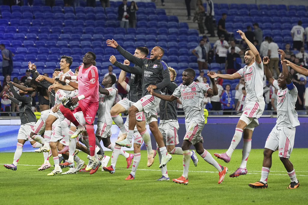 Lyon players celebrate their victory at the French League One soccer match between Olympique Lyon and Angers at Groupama stadium in Decines, outside Lyon, France, Friday, Sept. 19, 2025. (AP Photo/Laurent Cipriani)