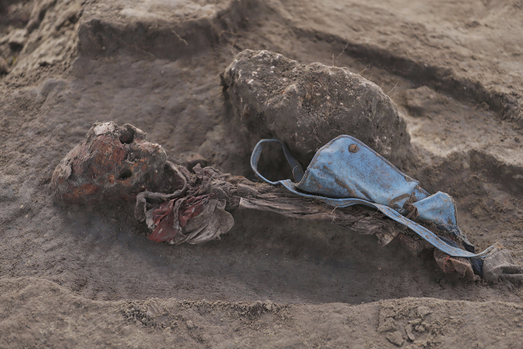 An exhumed human skeleton is seen with a school bag at the site of a mass grave in Chemmani, Sri Lanka, June 28, 2025. (AP Photo/Kanapathipillai Kumanan)