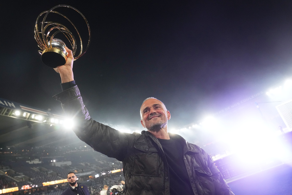 PSG's head coach Luis Enrique shows to the fans the 2025 Johann Cruyff trophy for the best coach of the year that he was awarded earlier in the week after the French League One soccer match between Paris Saint-Germain and Auxerre at the Parc des Princes in Paris, Saturday, Sept. 27, 2025. (AP Photo/Thibault Camus)