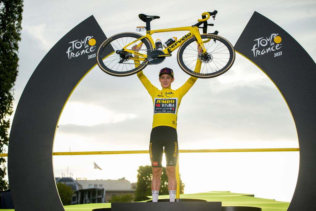 FILE - Tour de France winner Denmark's Jonas Vingegaard, wearing the overall leader's yellow jersey, celebrates on the podium after the last stage of the Tour de France cycling race in Paris, France, Sunday, July 23, 2023. (AP Photo/Daniel Cole, file)