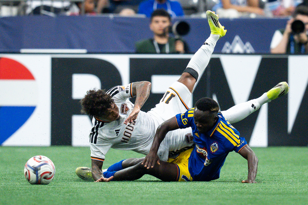 Houston Dynamo FC's Lawrence Ennali (11) and Vancouver Whitecaps' Cheick Sabaly (7) collide as they fight for the ball during the first half of an MLS soccer match in Vancouver, B.C., on Wednesday, Aug. 19, 2026. (Ethan Cairns/The Canadian Press via AP)