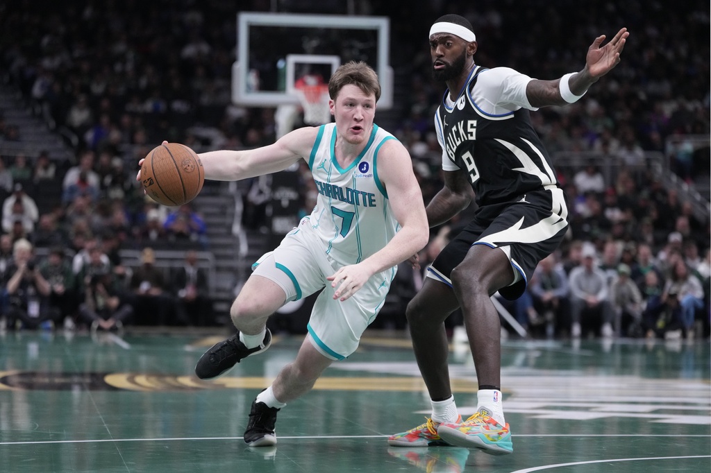 Charlotte Hornets' Kon Knueppel gets past Milwaukee Bucks' Bobby Portis during the first half of an NBA basketball game Friday, Nov. 14, 2025, in Milwaukee. (AP Photo/Morry Gash)