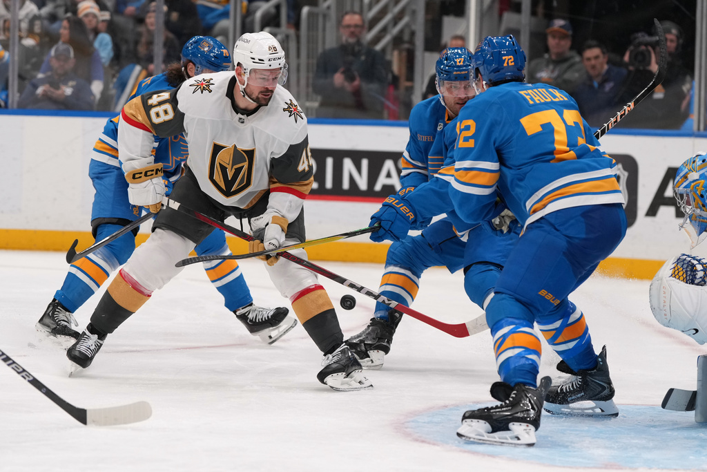 Vegas Golden Knights' Tomas Hertl (48) and St. Louis Blues' Justin Faulk (72) battle for a loose puck during the third period of an NHL hockey game Saturday, Nov. 15, 2025, in St. Louis. (AP Photo/Jeff Roberson)