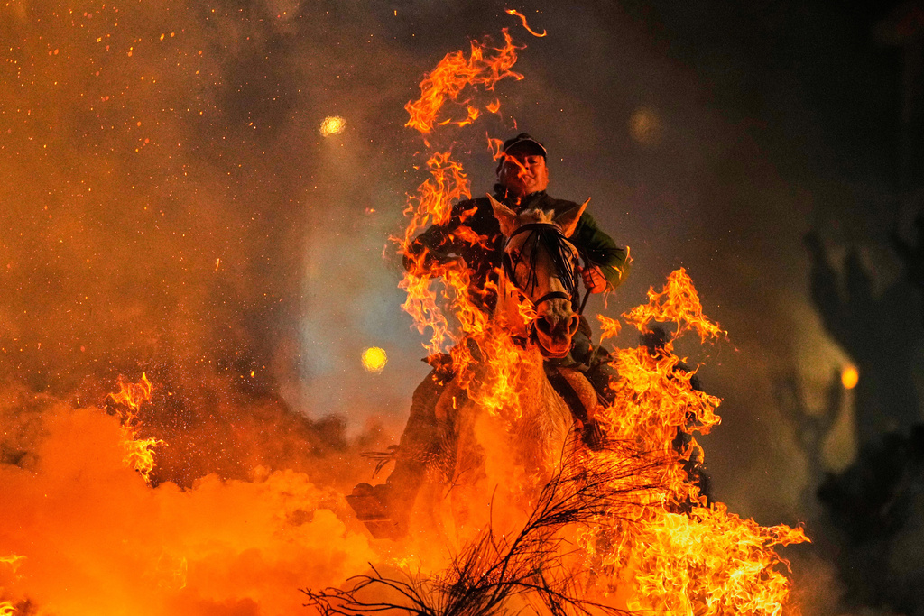A man rides a horse through a bonfire as part of a ritual in honor of Saint Anthony the Abbot, the patron saint of domestic animals, in San Bartolome de Pinares, Spain, Friday, Jan. 16, 2026. (AP Photo/Manu Fernandez)