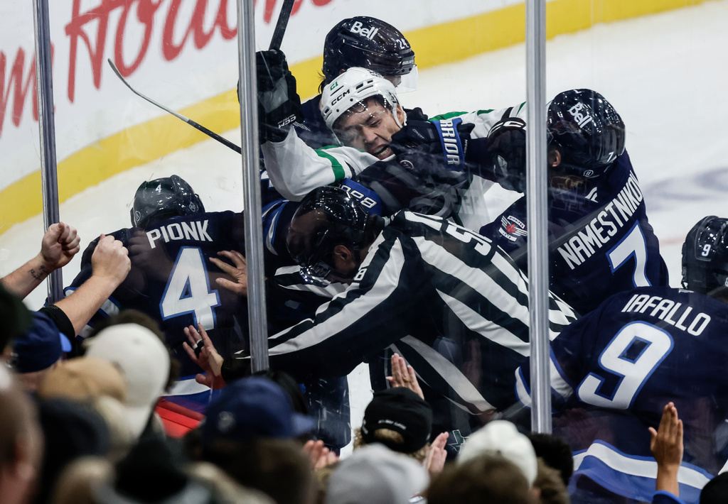 Winnipeg Jets' Vladislav Namestnikov (7) hits Dallas Stars' Jason Robertson (21) in a scuffle against the boards during second-period NHL hockey game action in Winnipeg, Manitoba, Thursday, Oct. 9, 2025. (John Woods/The Canadian Press via AP)