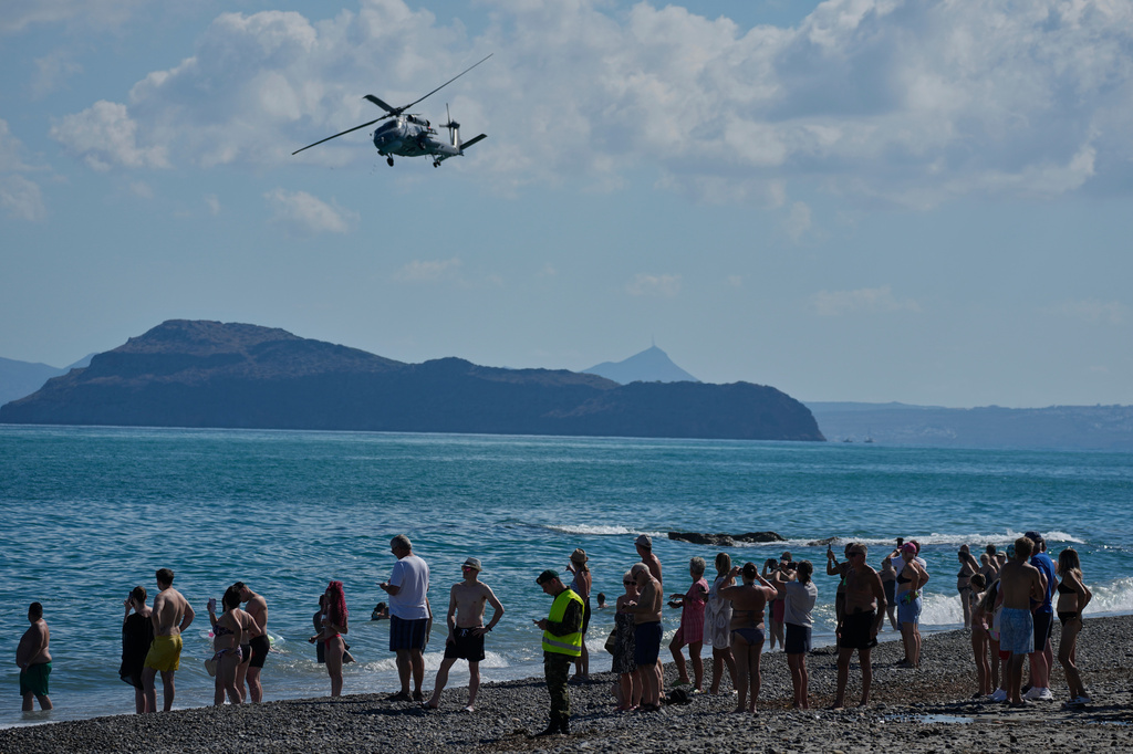 Tourists from nearby hotels watch a military helicopter fly overhead during Medusa 15, a multinational military exercise led by Greece and Egypt, at Maleme on the Greek island of Crete, Friday, Sept. 18, 2026. (AP Photo/Thanassis Stavrakis)