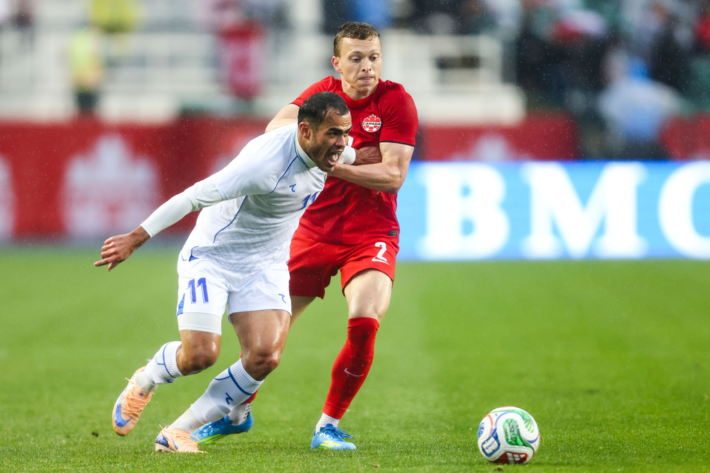 Canada's Alistair Johnston (2) battles against Uzbekistan's Oston Urunov (11) during the first half of an international friendly soccer match in Edmonton, Alberta, Monday, June 1, 2026. (Codie McLachlan/The Canadian Press via AP)
