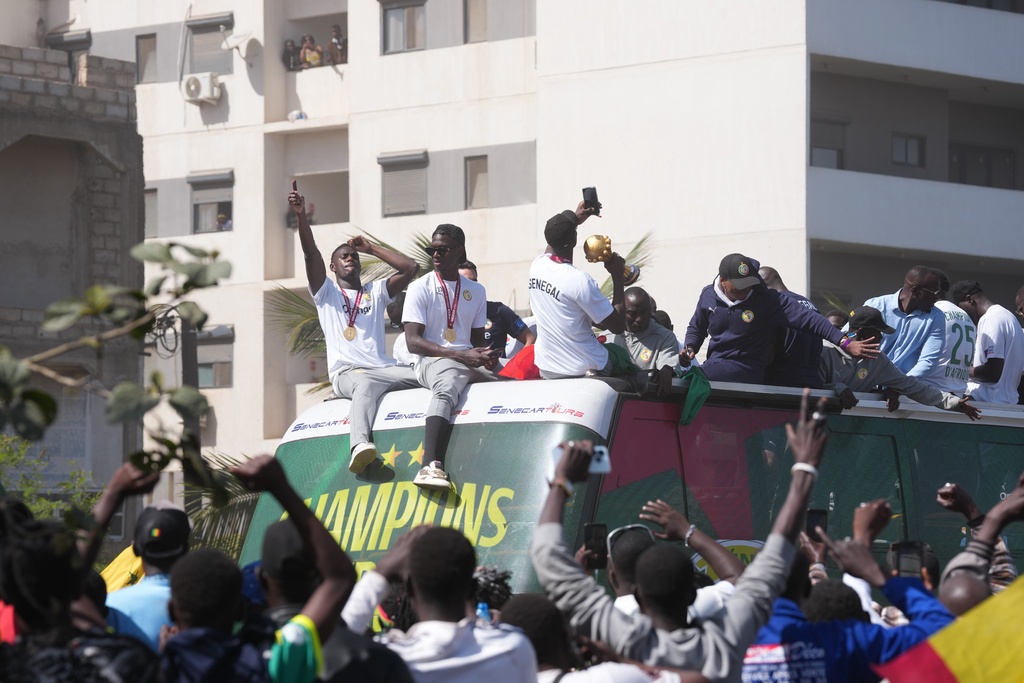 The Senegalese soccer team rides through thousands of cheering fans celebrating their victory in the Africa Cup of Nations soccer tournament, in Dakar, Senegal, Tuesday, Jan. 20, 2026. (AP Photo/Misper Apawu)