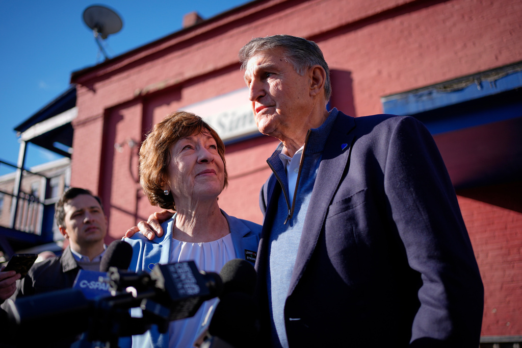 Sen. Susan Collins listens as former West Virginia Sen. Joe Manchin speaks to reporters following a campaign stop Wednesday, Oct. 21, 2026, in Lewiston, Maine. (AP Photo/Robert F. Bukaty)