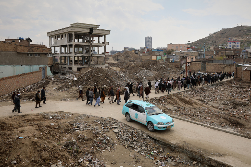 Mourners walk in a funeral procession past rubble left after buildings were demolished to widen the streets in Kabul, Afghanistan, Monday, April 6, 2026. (AP Photo/Siddiqullah Alizai)