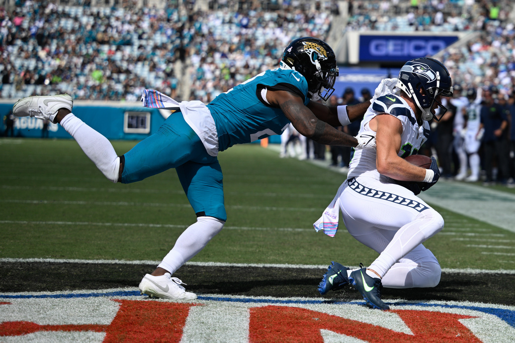 Seattle Seahawks wide receiver Cooper Kupp (10) catches a pass for a touchdown as Jacksonville Jaguars cornerback Jourdan Lewis defends during the second half of an NFL football game Sunday, Oct. 12 2025, in Jacksonville, Fla. (AP Photo/Phelan M. Ebenhack)