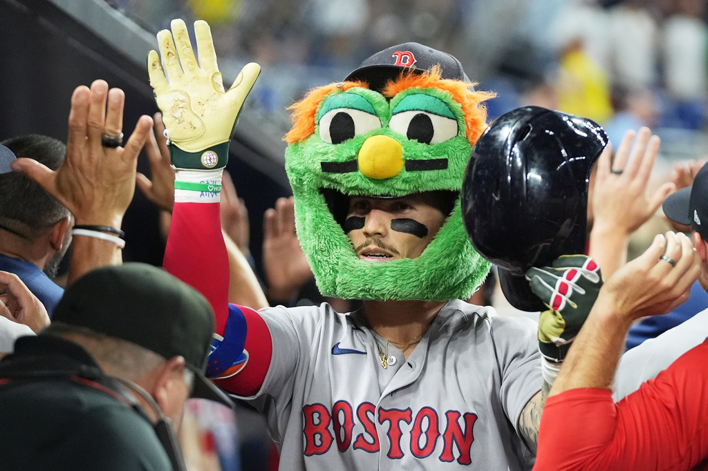 Boston Red Sox's Jarren Duran is congratulated in the dugout after hitting a grand slam during the eleventh inning of a baseball game against the Miami Marlins, Tuesday, Aug. 25, 2026, in Miami. (AP Photo/Lynne Sladky)