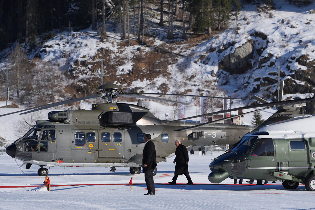 President Donald Trump, center right, walks on a red carpet after exiting Marine One during arrival for the Annual Meeting of the World Economic Forum in Davos, Switzerland, Wednesday, Jan. 21, 2026. (AP Photo/Evan Vucci)