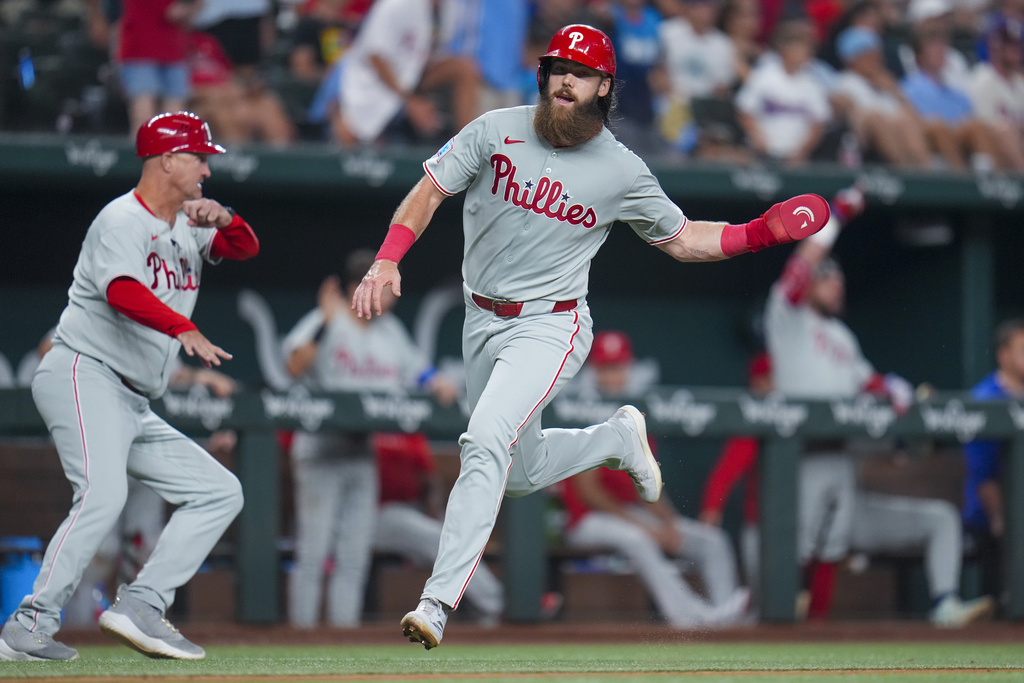 Philadelphia Phillies' Brandon Marsh runs home while scoring on a two-run double by teammate Max Kepler during the seventh inning of a baseball game against the Texas Rangers Saturday, Aug. 9, 2025, in Arlington, Texas. (AP Photo/Julio Cortez)