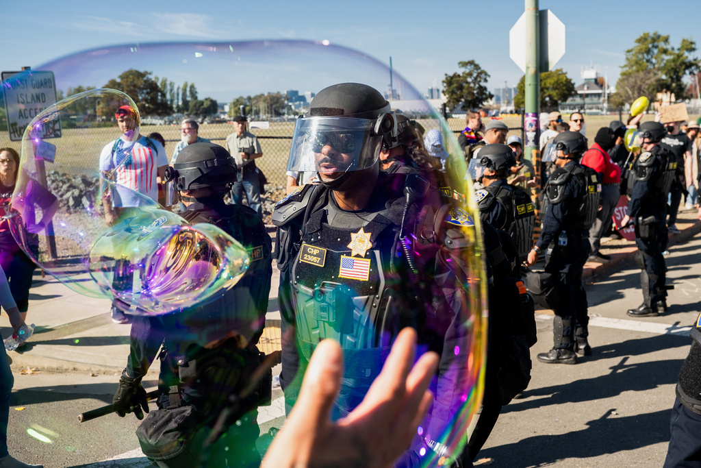 California Highway Patrol officers move back protesters who were blocking the entrance to Coast Guard Base Alameda on Thursday, Oct. 23, 2025, in Oakland, Calif. (AP Photo/Noah Berger)