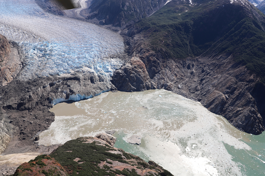 This photo provided by the U.S. Geological Survey shows the terminus of the South Sawyer Glacier in Tracy Arm fjord, alongside the remains of a landslide, left, that occurred days earlier, Aug. 13, 2025, about 80 miles southeast of Juneau, Alaska. (John Lyons/U.S. Geological Survey via AP)