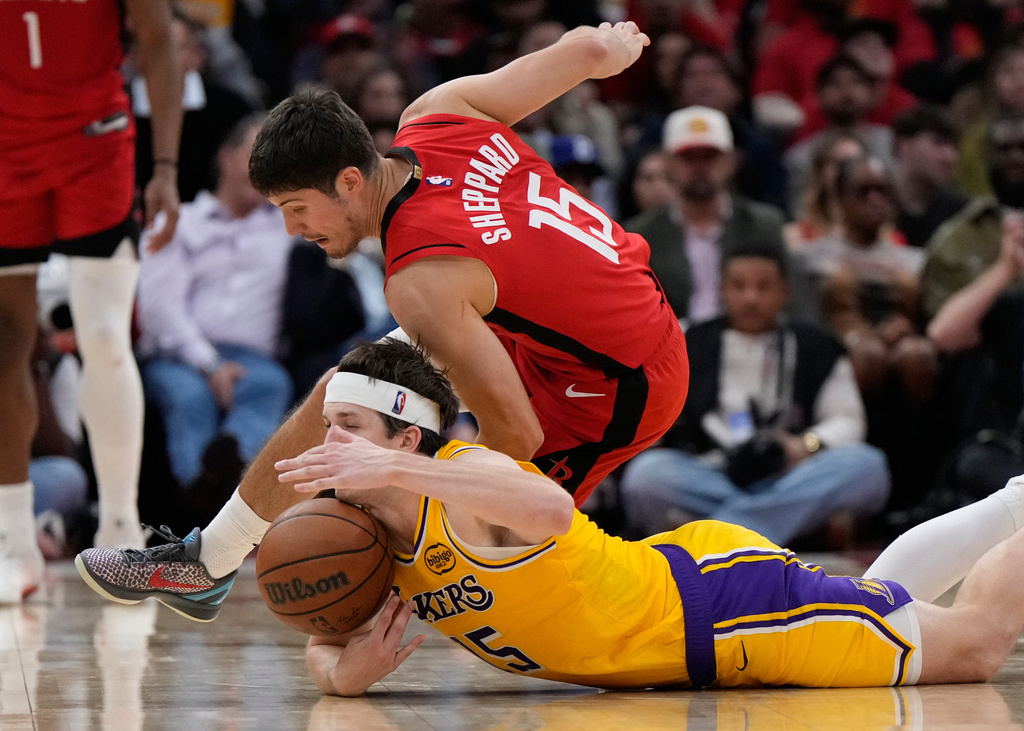 Houston Rockets guard Reed Sheppard (15) and Los Angeles Lakers guard Austin Reaves (15) reach for a loose ball during the second half of Game 6 of a first-round NBA playoffs basketball series in Houston, Friday, May 1, 2026. (AP Photo/Ashley Landis)