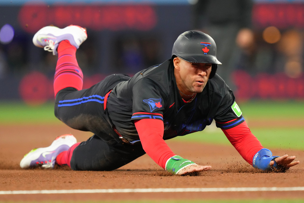 Toronto Blue Jays' George Springer (4) slides into third base against the Pittsburgh Pirates during third inning of a baseball game in Toronto, Friday, May 22, 2026. (Chris Young/The Canadian Press via AP)