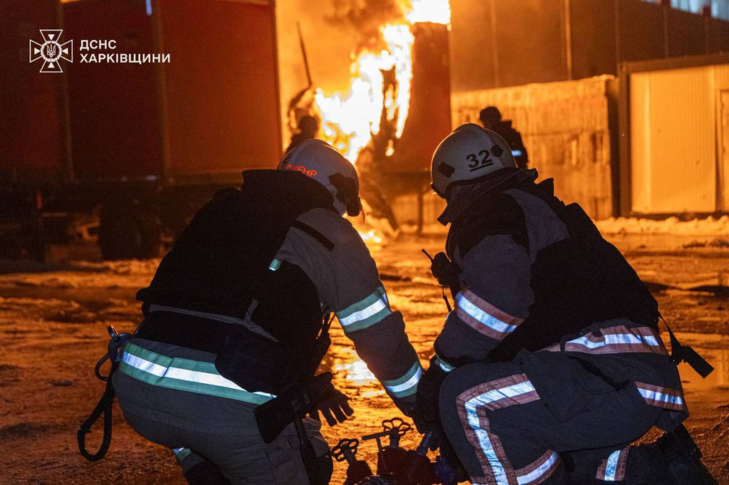 In this photo provided by the Ukrainian Emergency Service, emergency services personnel work to extinguish a fire following a Russian attack in Kharkiv, Ukraine, Tuesday, Jan. 13, 2026. (Ukrainian Emergency Service via AP)