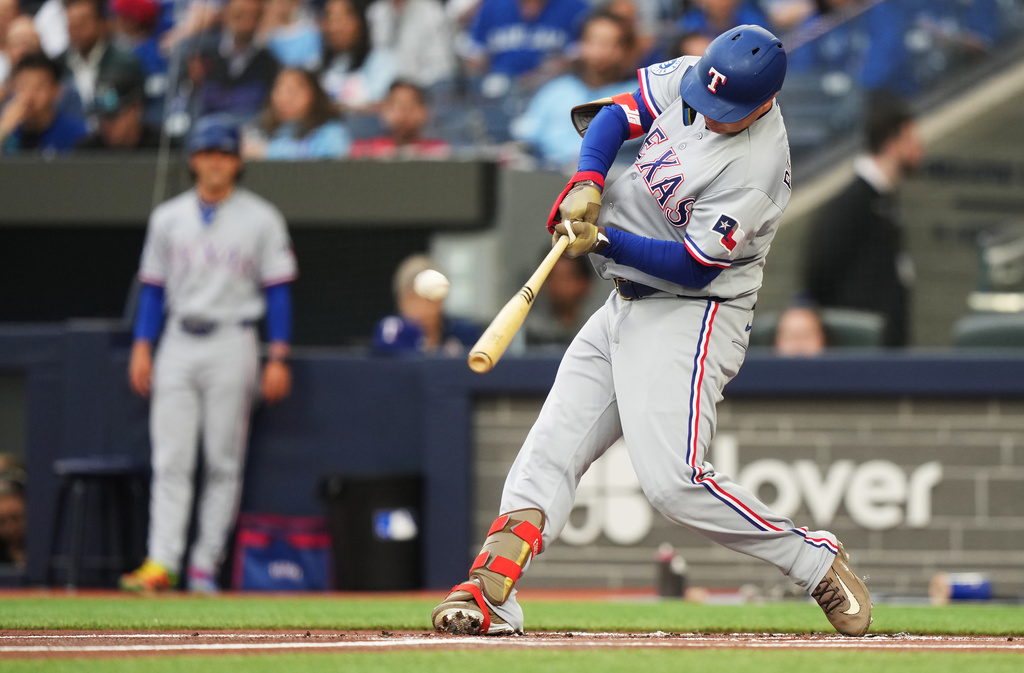Texas Rangers designated hitter Joc Pederson (3) hits a solo home run against the Toronto Blue Jays during the first inning of a baseball game in Toronto, Thursday, June 25, 2026. (Nathan Denette/The Canadian Press via AP)