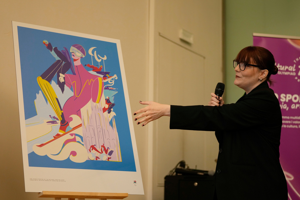 Carolina Altavilla gestures next to Milano-Cortina 2026 Winter Paralympic iconic poster during a press conference at Milan's Triennale permanent exhibition in Milan, Italy, Wednesday, Oct. 22, 2025. (AP Photo/Luca Bruno)