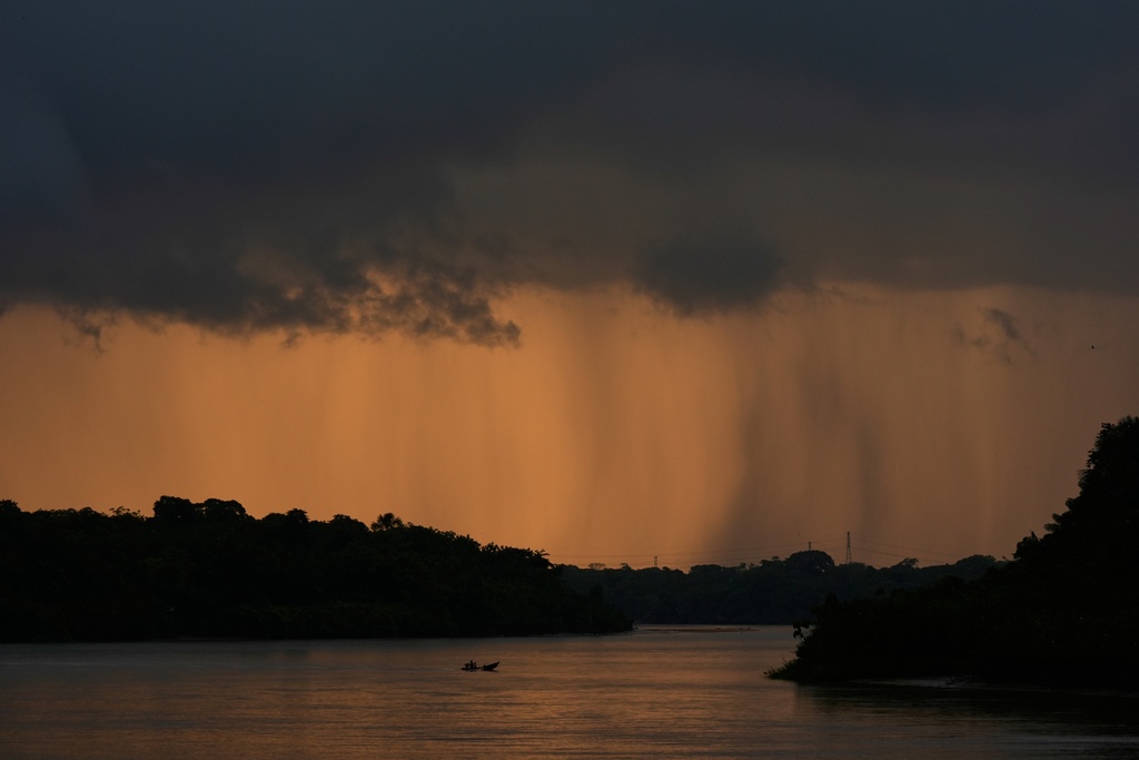 A small boat crosses a river approaching Itacoa Miri, Brazil, Tuesday, Nov. 18, 2025. (AP Photo/Fernando Llano)