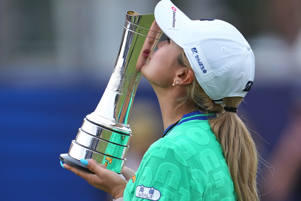 Shiho Kuwaki, of Japan, kisses the trophy after winning the Women's British Open golf championship in Lytham St Annes, England, Sunday, Aug. 2, 2026. (AP Photo/Jon Super)