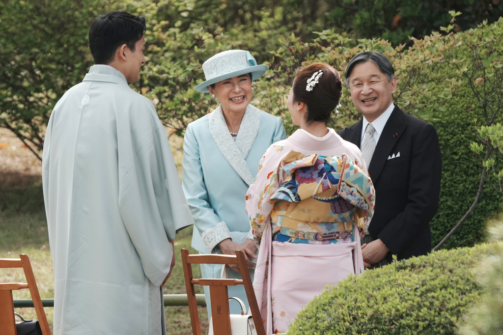 Japan's Emperor Naruhito, right, and Empress Masako, third right, chat with guests, Japanese Olympic figure skating pairs champions Riku Miura, second right, and Ryuichi Kihara during their spring garden party at the Akasaka Palace's imperial garden in Tokyo, Friday, April 17, 2026. (Kazuhiro Nogi/Pool Photo via AP)