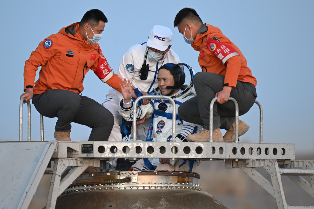 In this photo released by Xinhua News Agency, astronaut Zhang Lu, commander of Shenzhou-21 crews waves as he is carried out of the re-entry capsule after it landed successfully at the Dongfeng landing site in northern China's Inner Mongolia Autonomous Region on Friday, May 29, 2026. (Lian Zhen/Xinhua via AP)