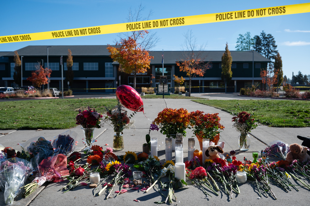 Flowers and candles are seen at a makeshift memorial outside Silver Rail Elementary in Bend, Ore., Friday, Oct. 16, 2026, a day after a deadly shooting. (AP Photo/Joe Kline)