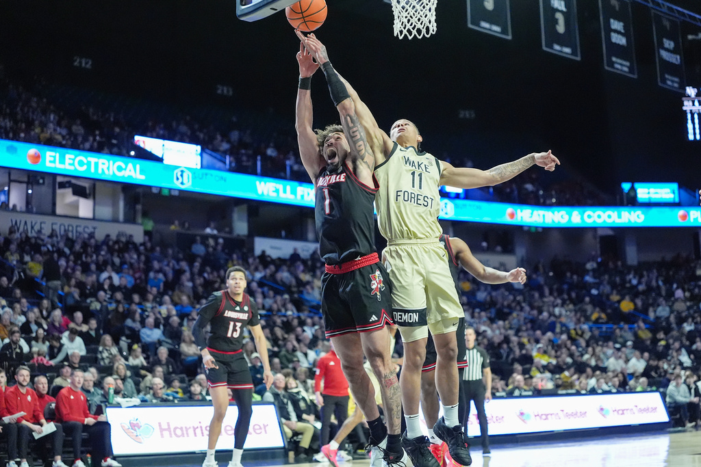 Wake Forest forward Marqus Marion (11) and Louisville guard J'vonne Hadley (1) battle for a rebound during the first half of an NCAA college basketball game, Saturday, Feb. 7, 2026, in Winston-Salem, N.C. (AP Photo/Matt Kelley)
